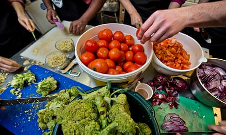 mesa com legumes a ser preparados por várias mãos